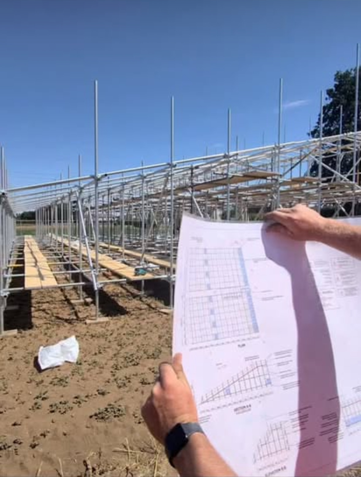 Engineer’s design drawing held up in front of the slide scaffold during the build at Millets Farm