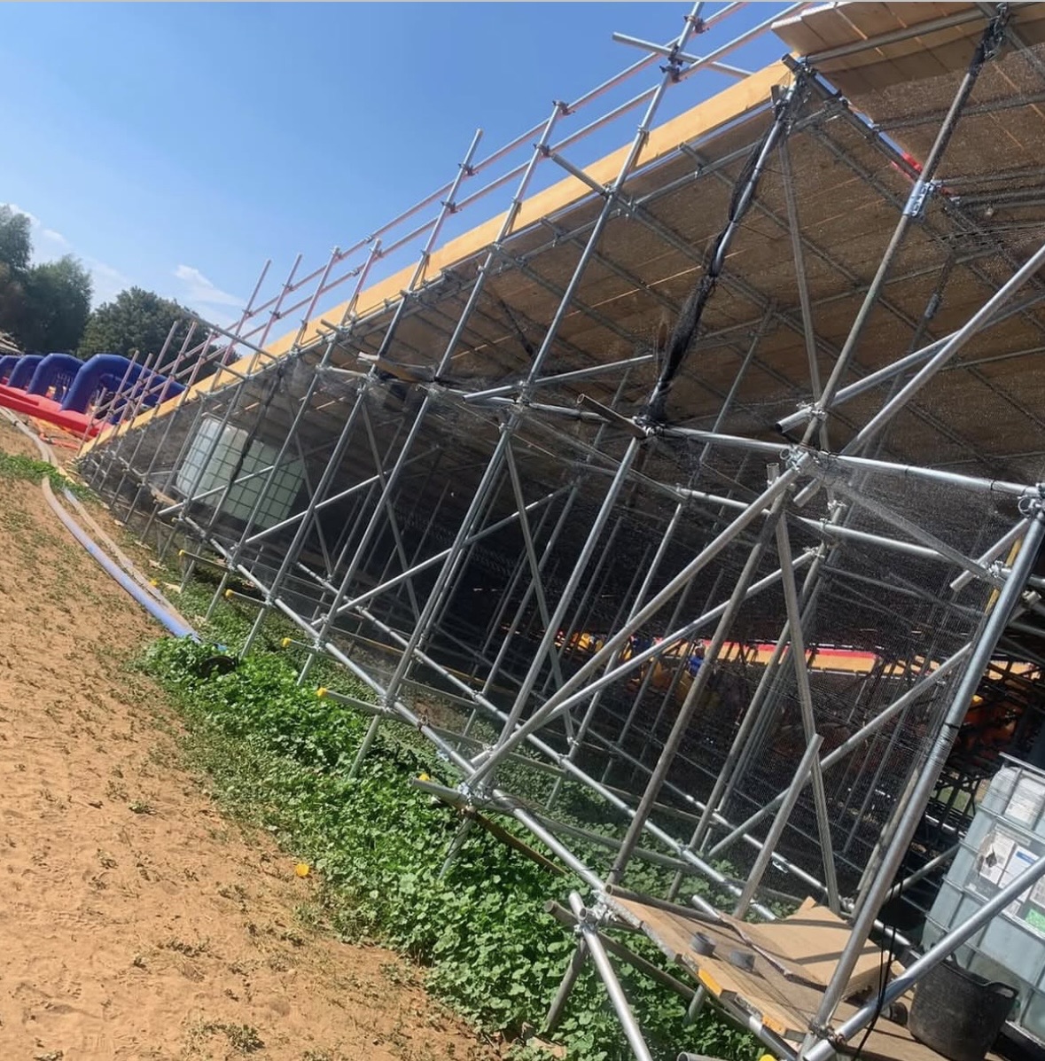 Netted and braced scaffold structure supporting the Slip n Slide lanes, with water tanks housed inside